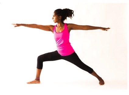 Woman in pink and black sportwear doing the warrior II pose