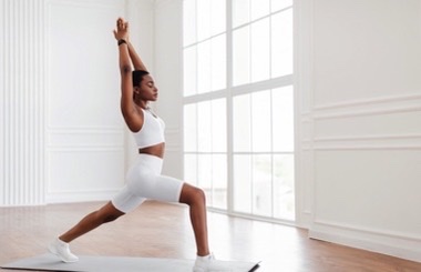 woman in white sportwear doing the warrior I pose