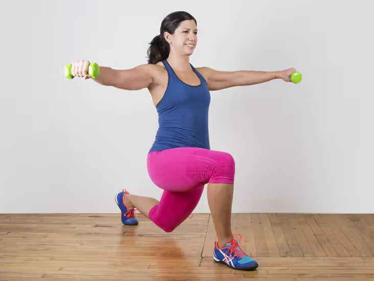 woman alternating lunge with lateral and front raises, from the side