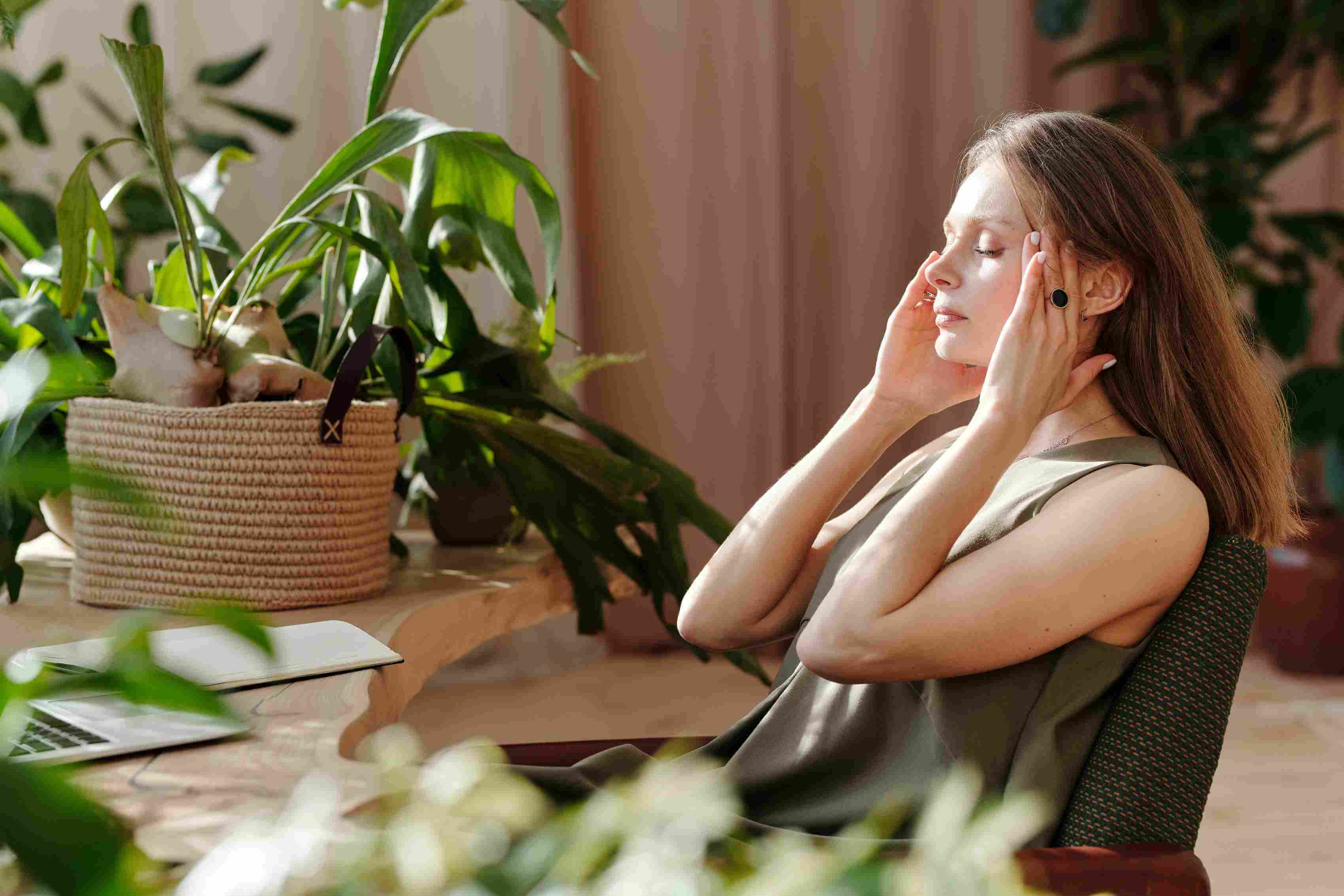 Woman-in-front-of-window-touching-her-head-because-of-headache