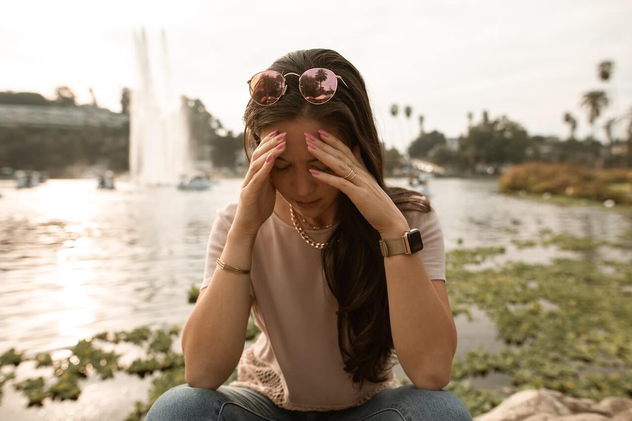 woman-outdoors-with-fatigue-touching-head