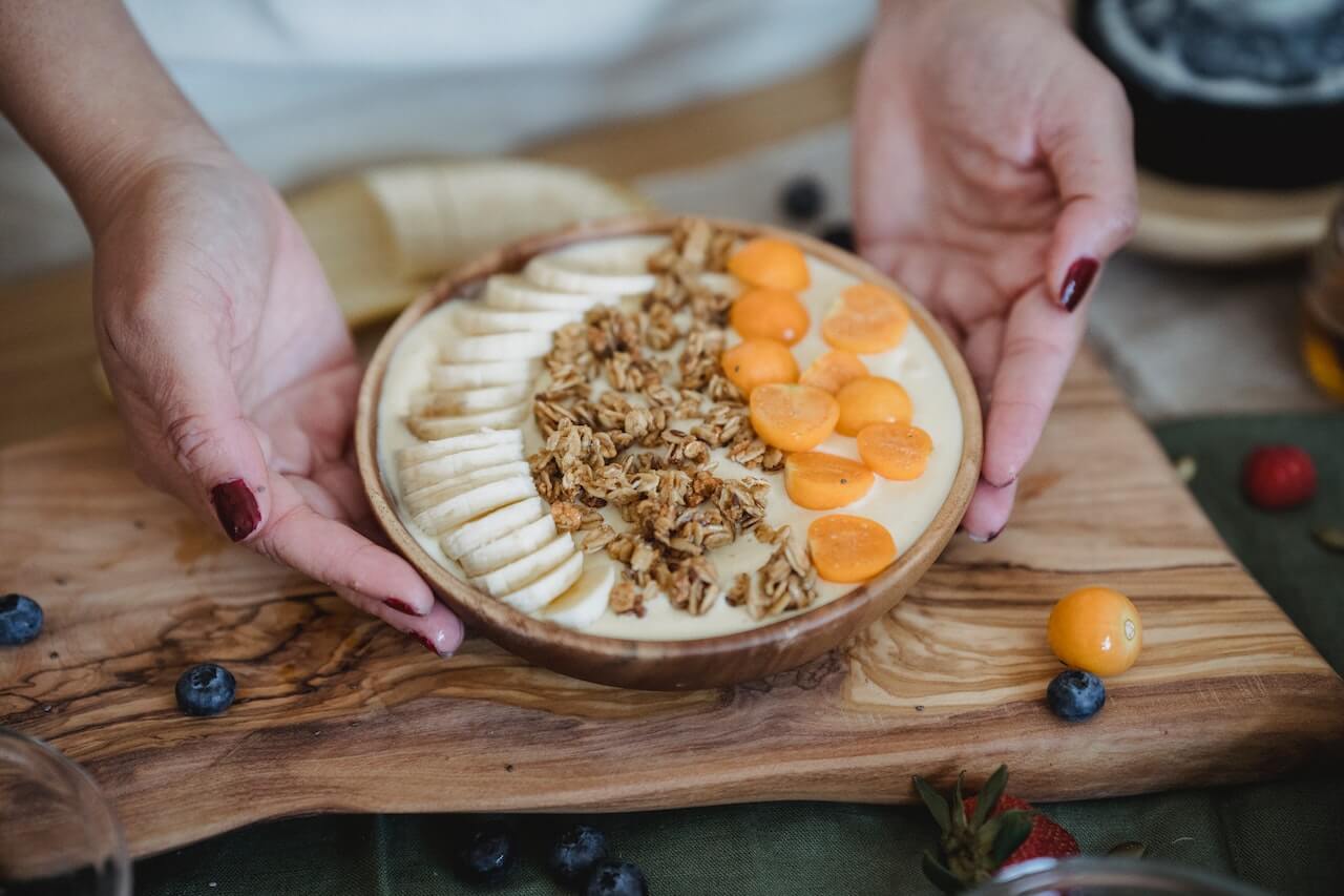 a-woman-serving-a-granola-bowl