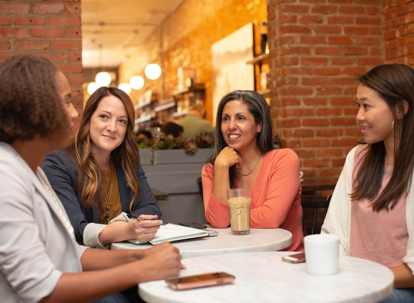 Women of different ages and ethic backgrounds having coffee and talking