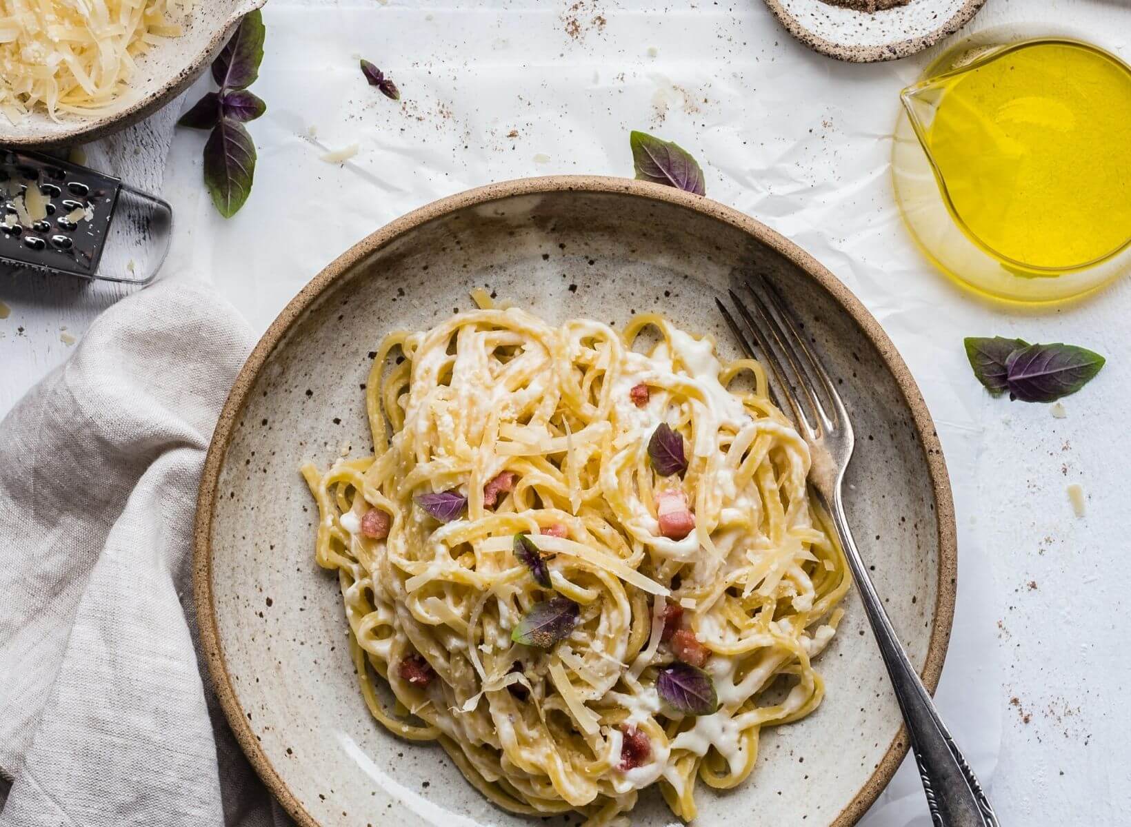 image of a white plate and silver fork with white pasta, a food to avoid for weight loss