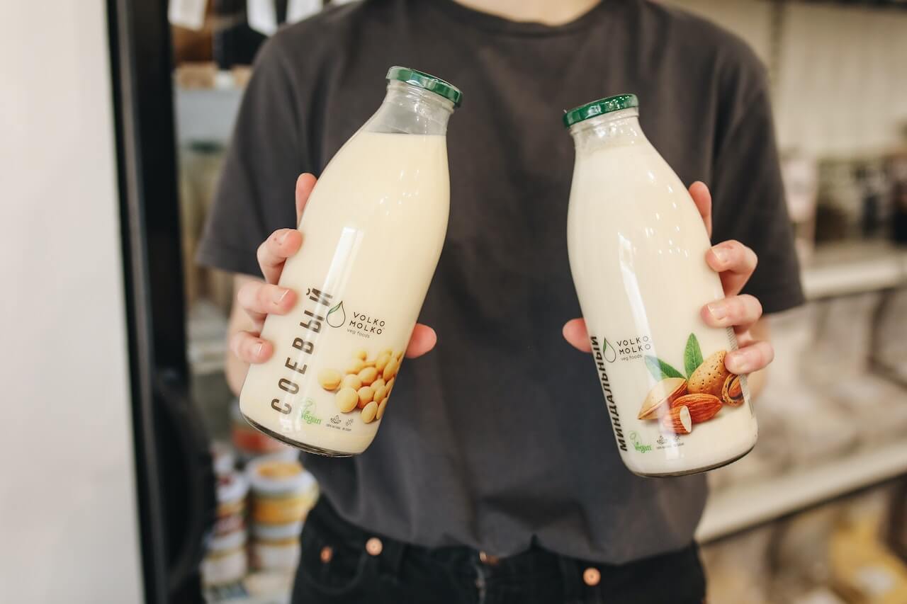 man-holding-two-bottles-of-almond-milk