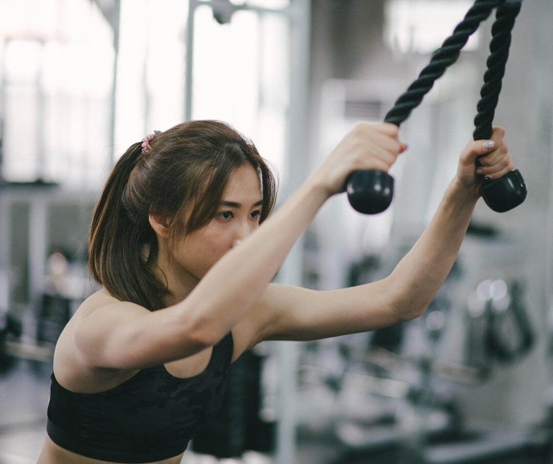 woman doing lat pulldowns at the gym