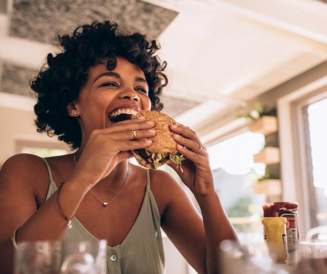 woman biting into a hamburger