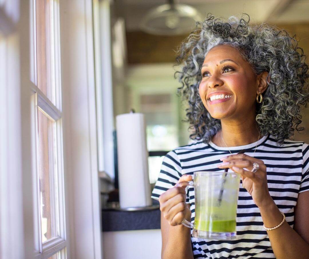 woman drinking a green smoothie