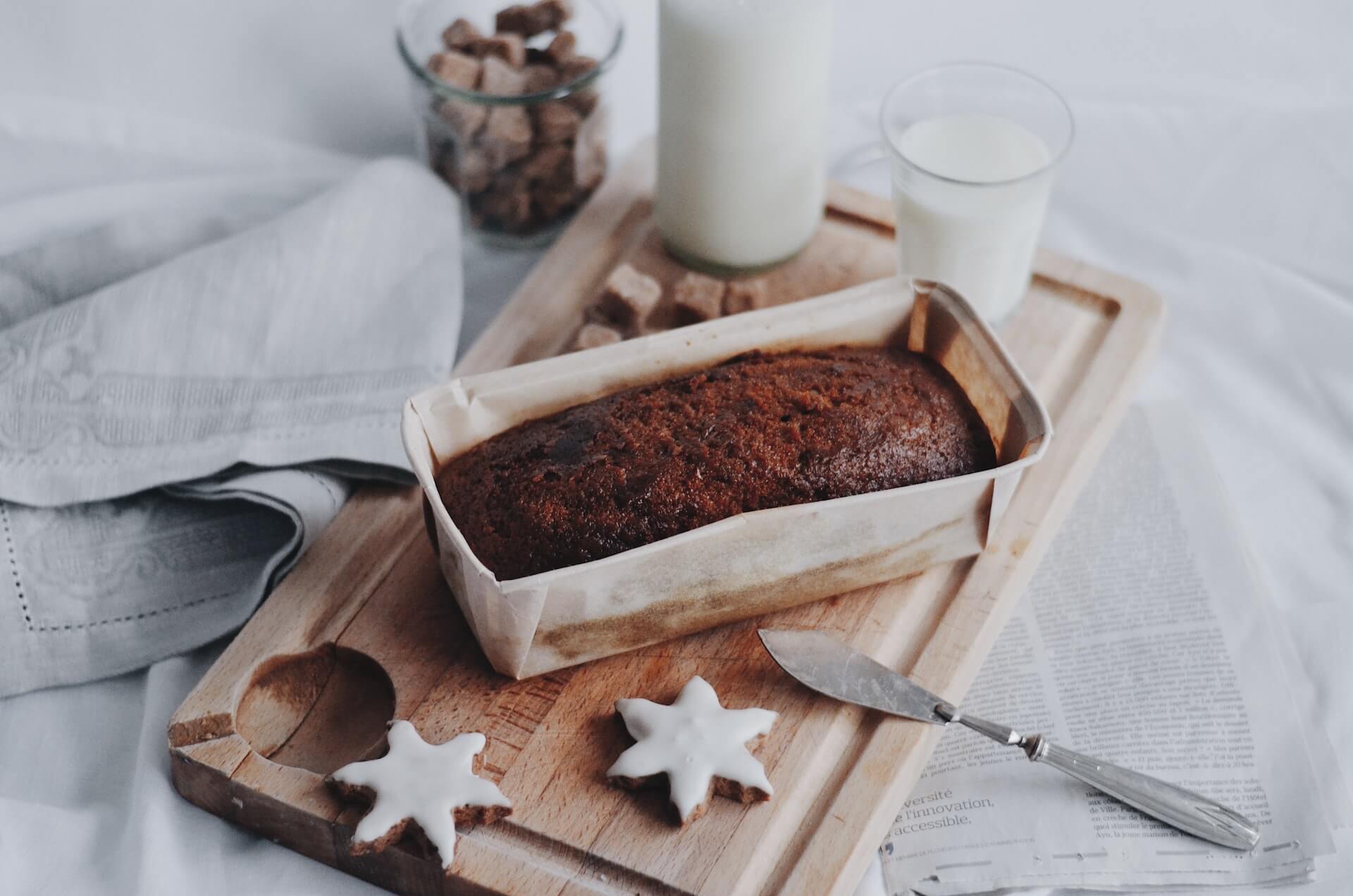 Gingerbread-cake-on-wodden-board-next-to-glasses-of-milk