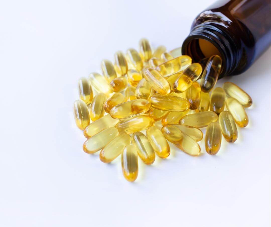 omega-3 fish oil supplements spilling out of a brown glass jar