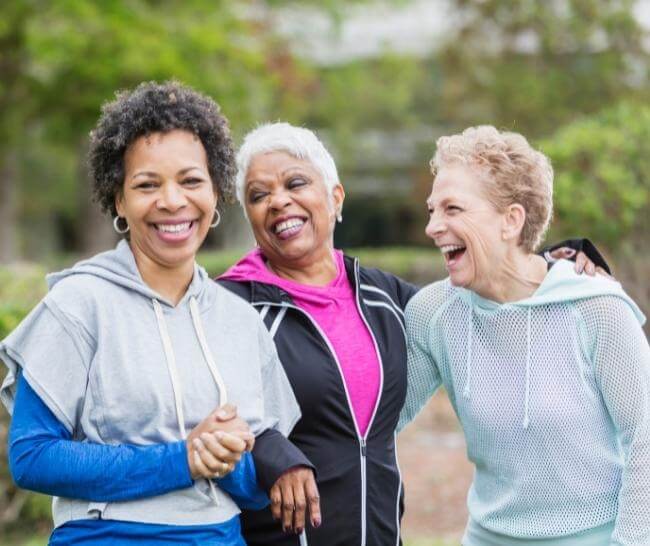 three women laughing while on a springtime walk