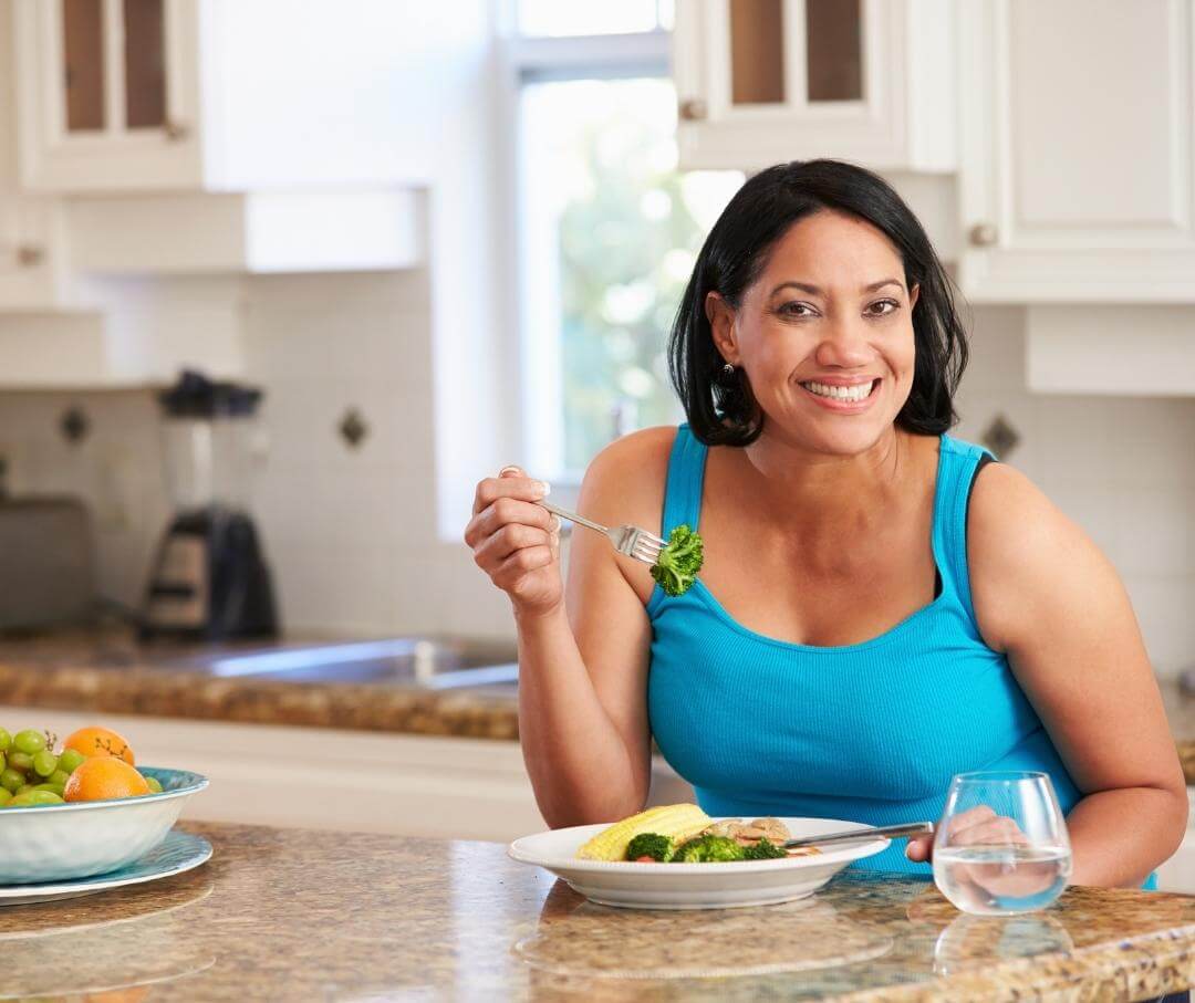 woman eating a healthy lunch at her kitchen island