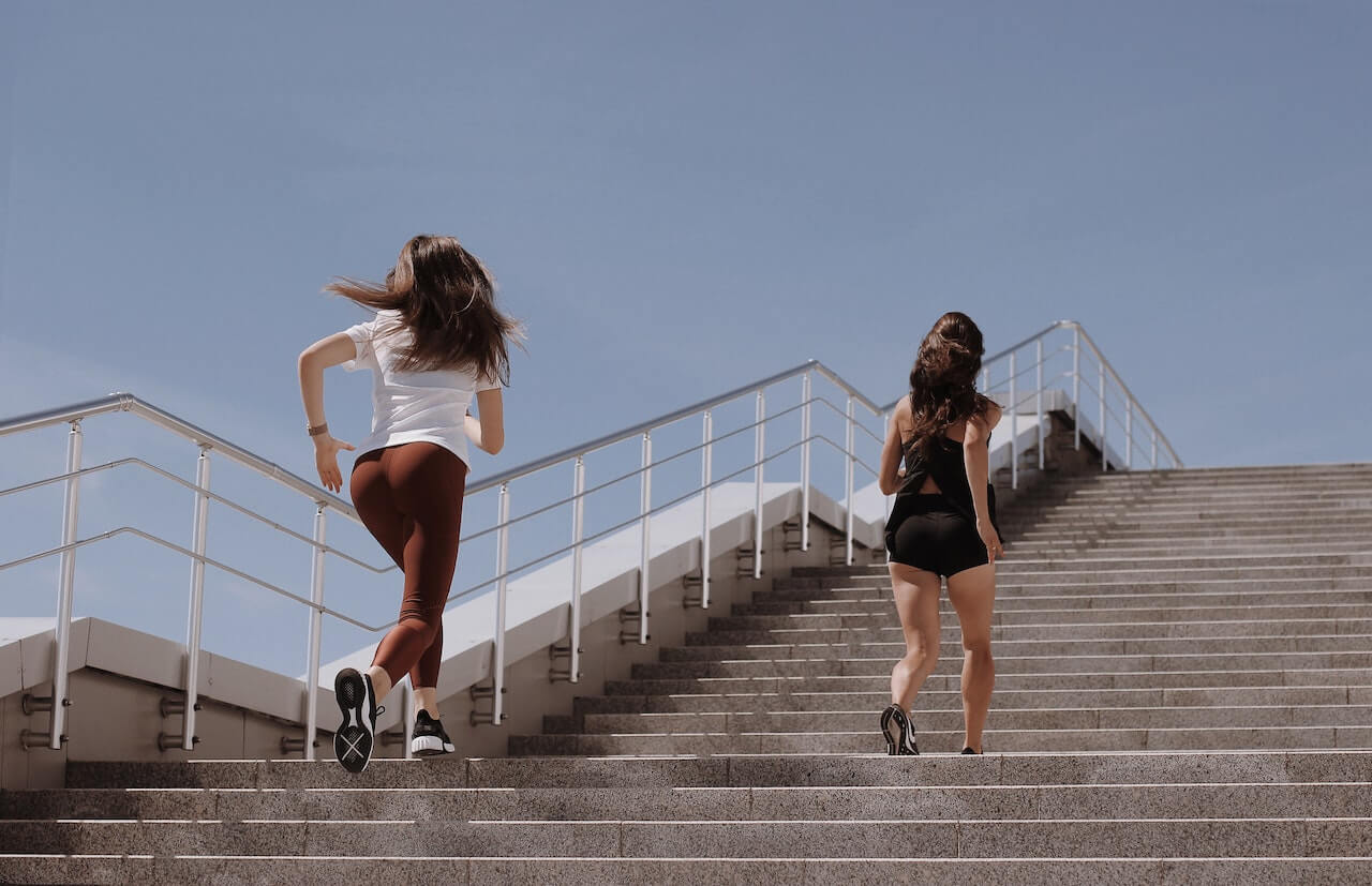 Two-women-running-on-outdoor-stairs