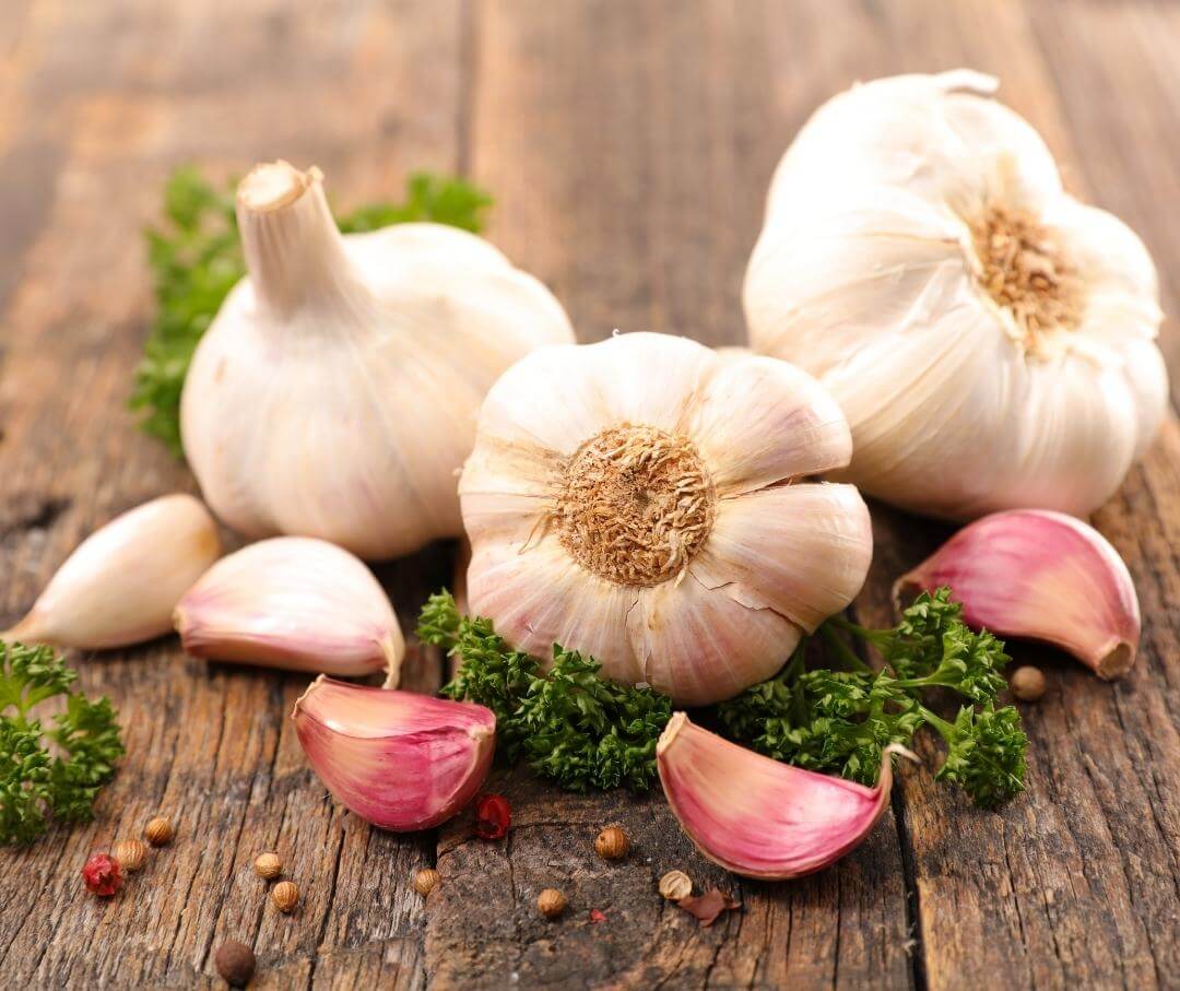 cloves of raw garlic on a wood table