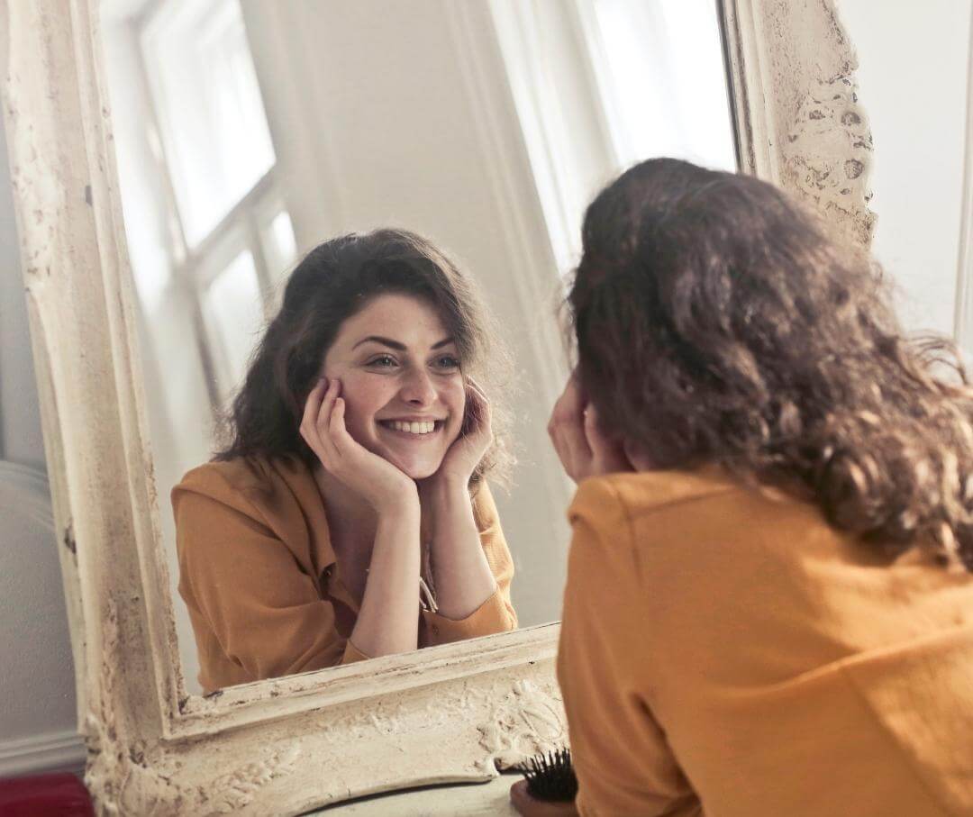 woman looking in a mirror and smiling