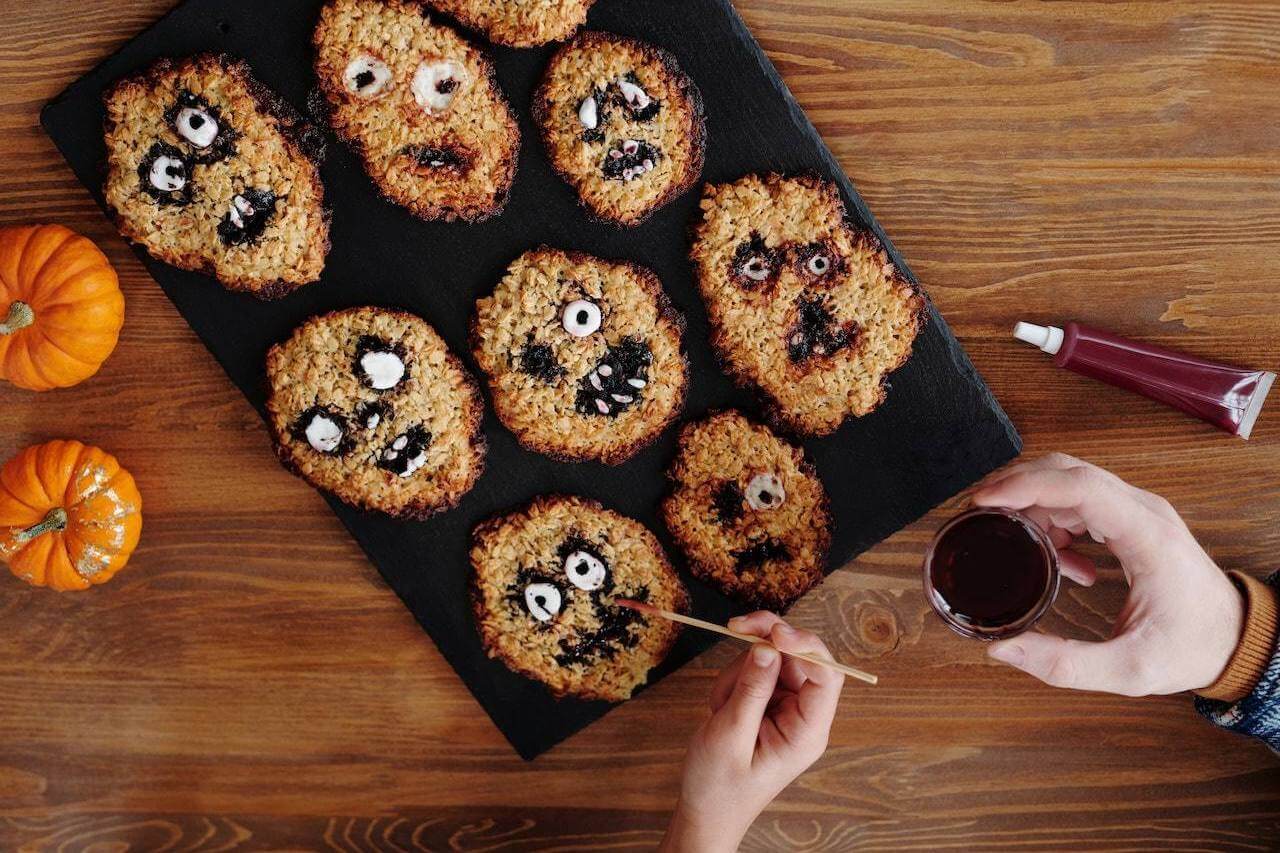 persons-hand-painting-eyes-on-oatmeal-cookies-for-halloween