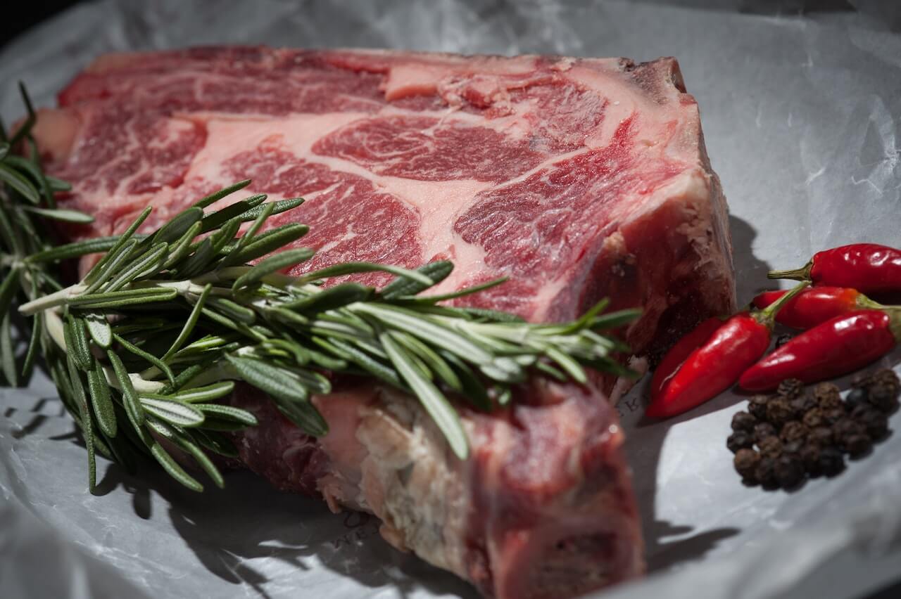 raw-steak-with-rosemary-and-chili-peppers