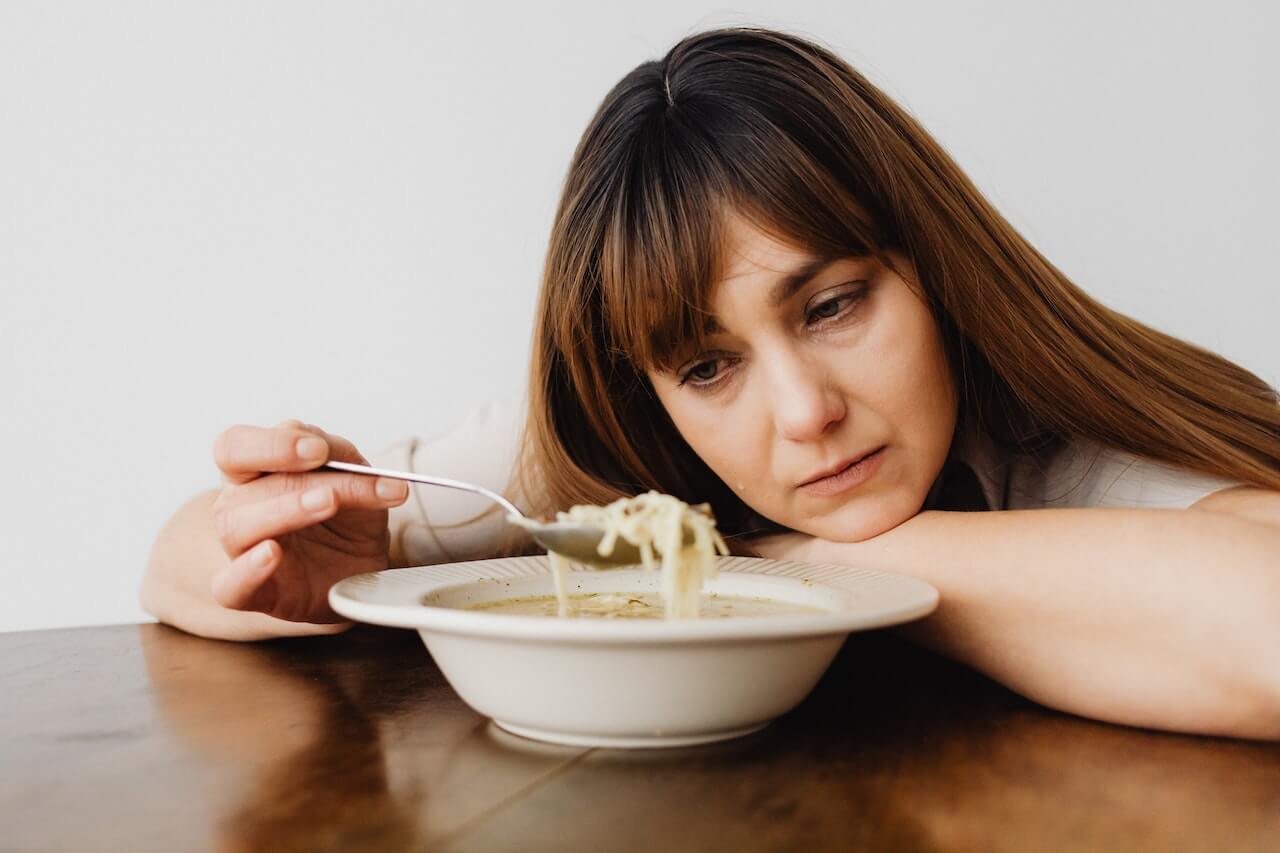 Close-up-of-a-sad-woman-eating-soup