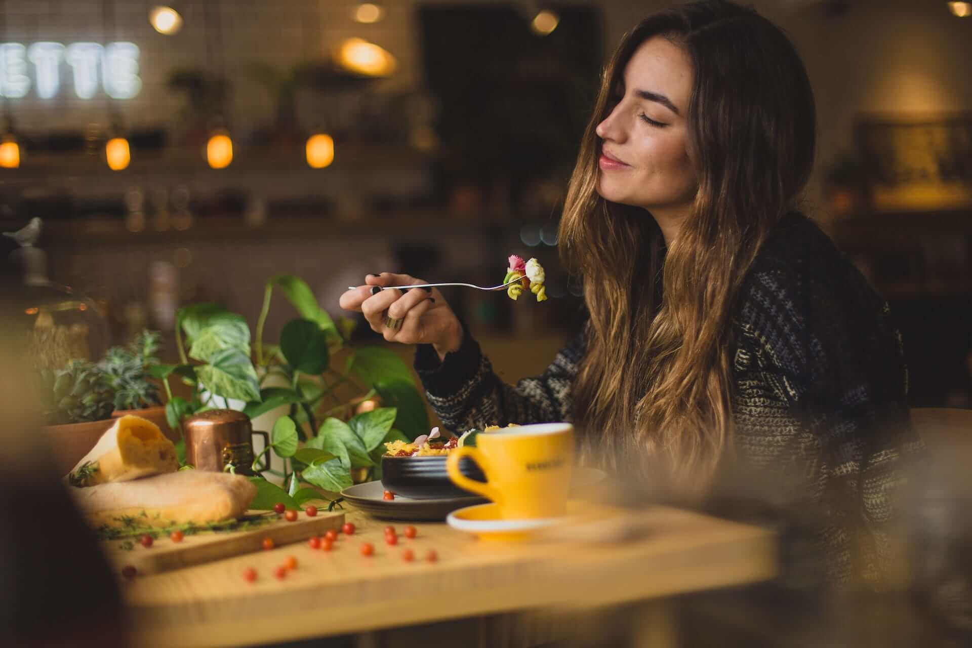 Young-woman-happily-enjoying-a-calm-meal-how-to-eat-slower