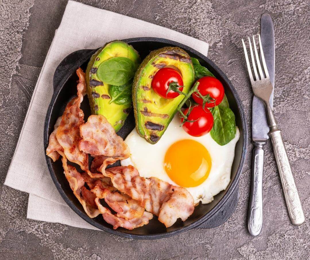 a keto breakfast including avocado, bacon and egg