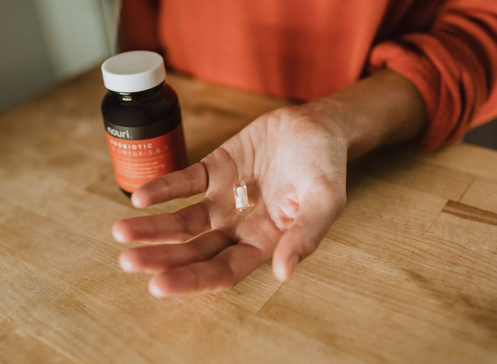 A close up shot of a hand holding a probiotic pill