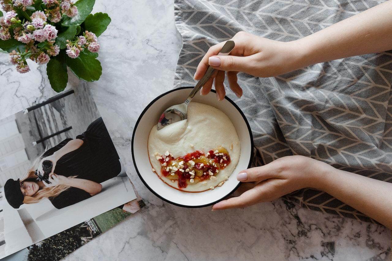 Grits-on-a-bowl-with-someones-hand-on-a-spoon