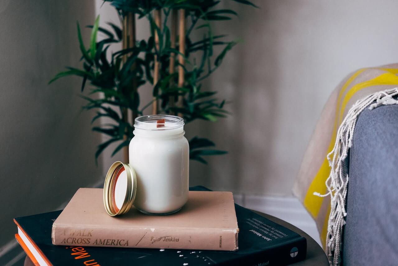 cristal clear jar full of milk on a little coffee table with books