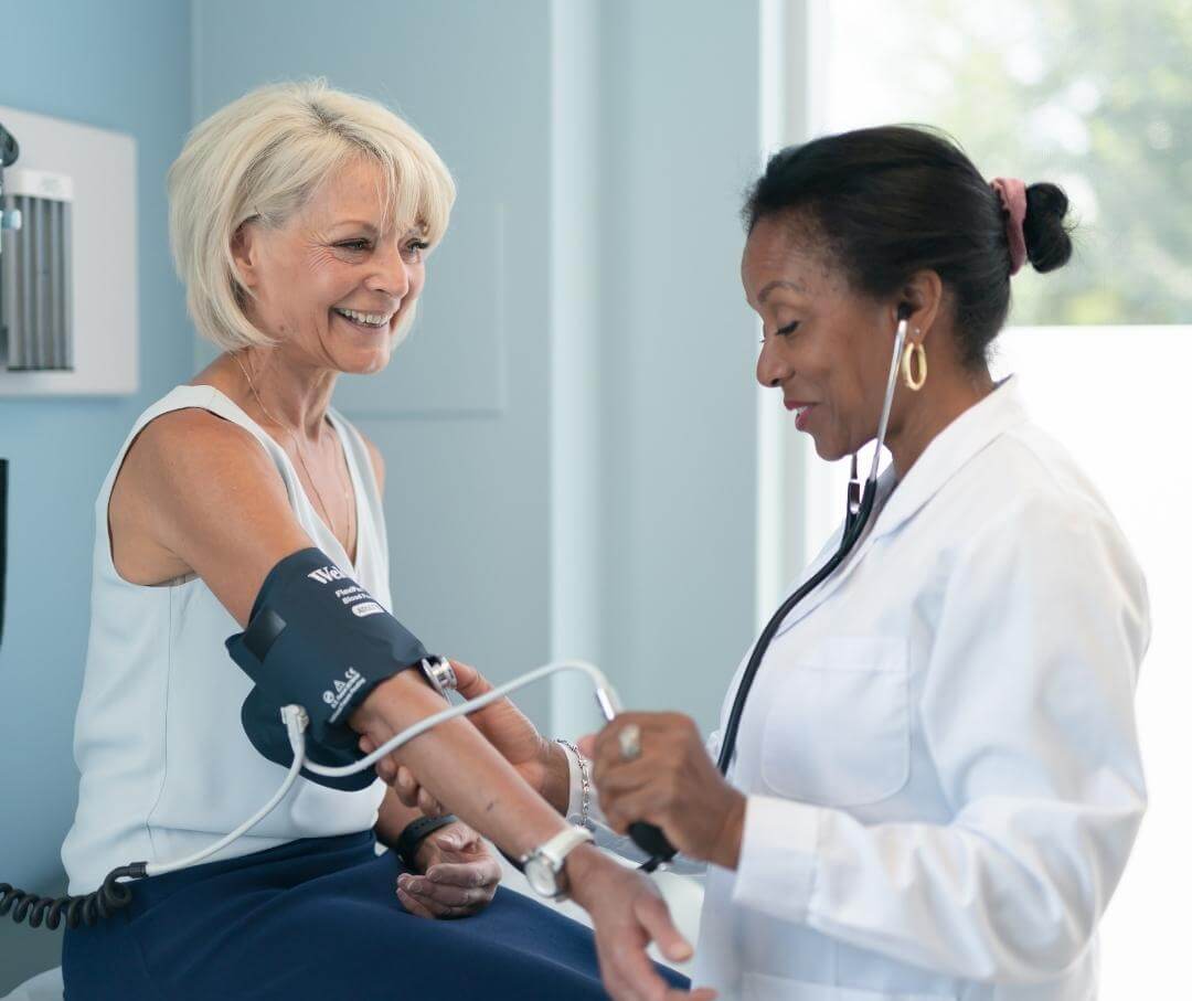 a woman getting her blood pressure checked by a doctor