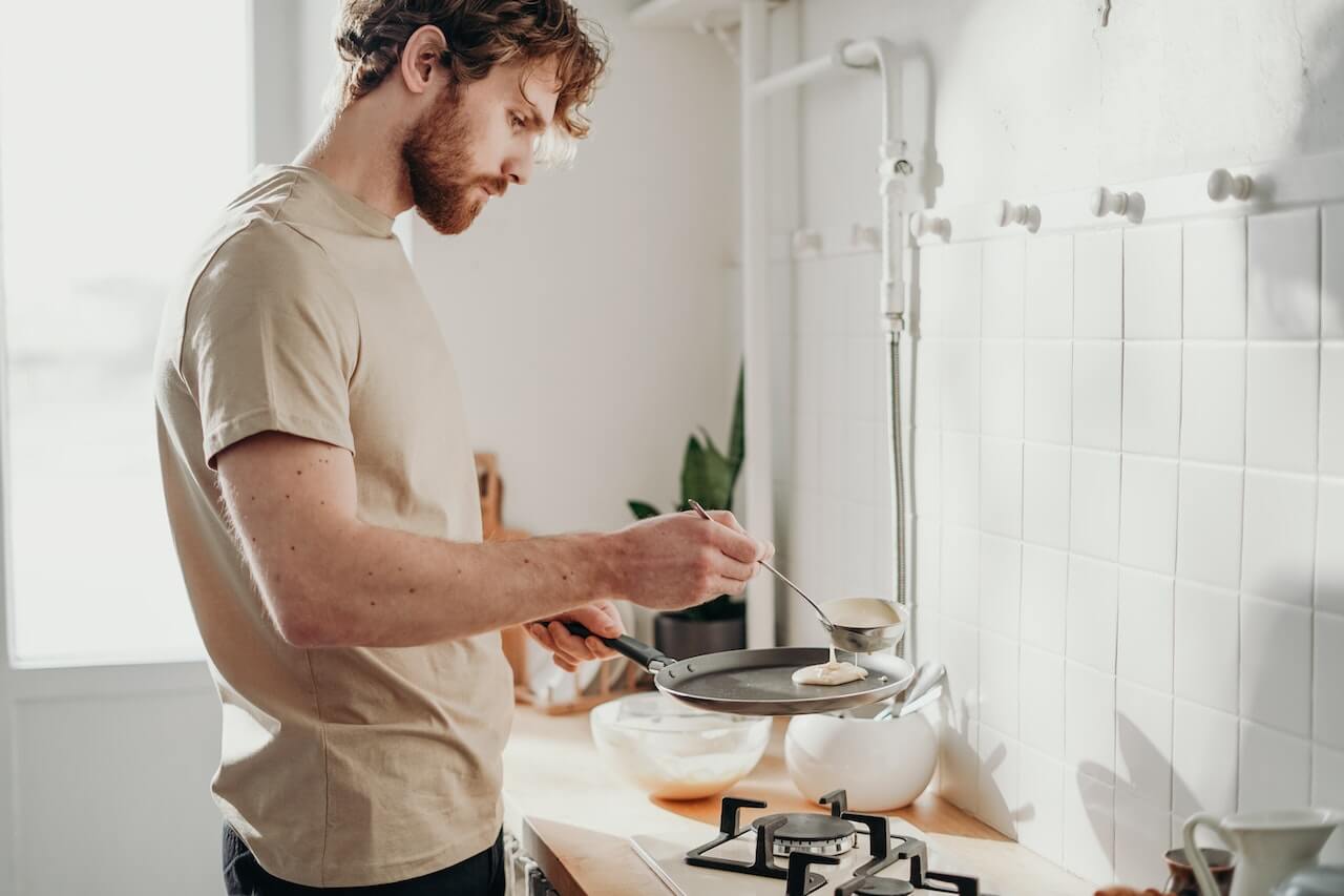 man cooking pancakes in the kitchen