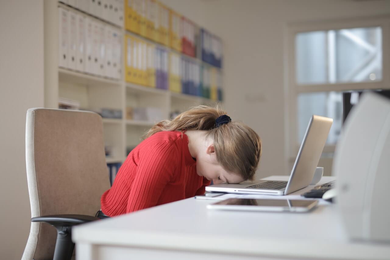 sleepy woman resting on desk