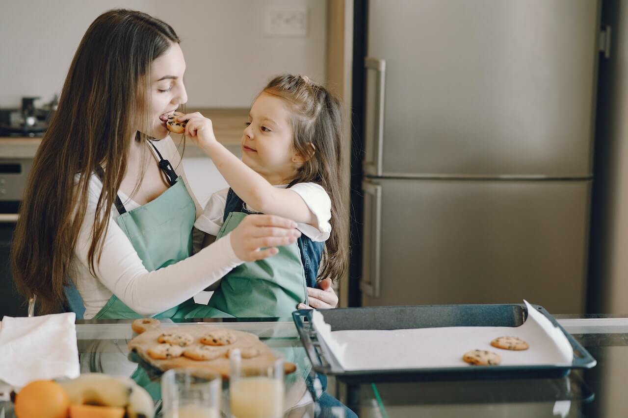 woman-cooking-cookies-with-young-daughter