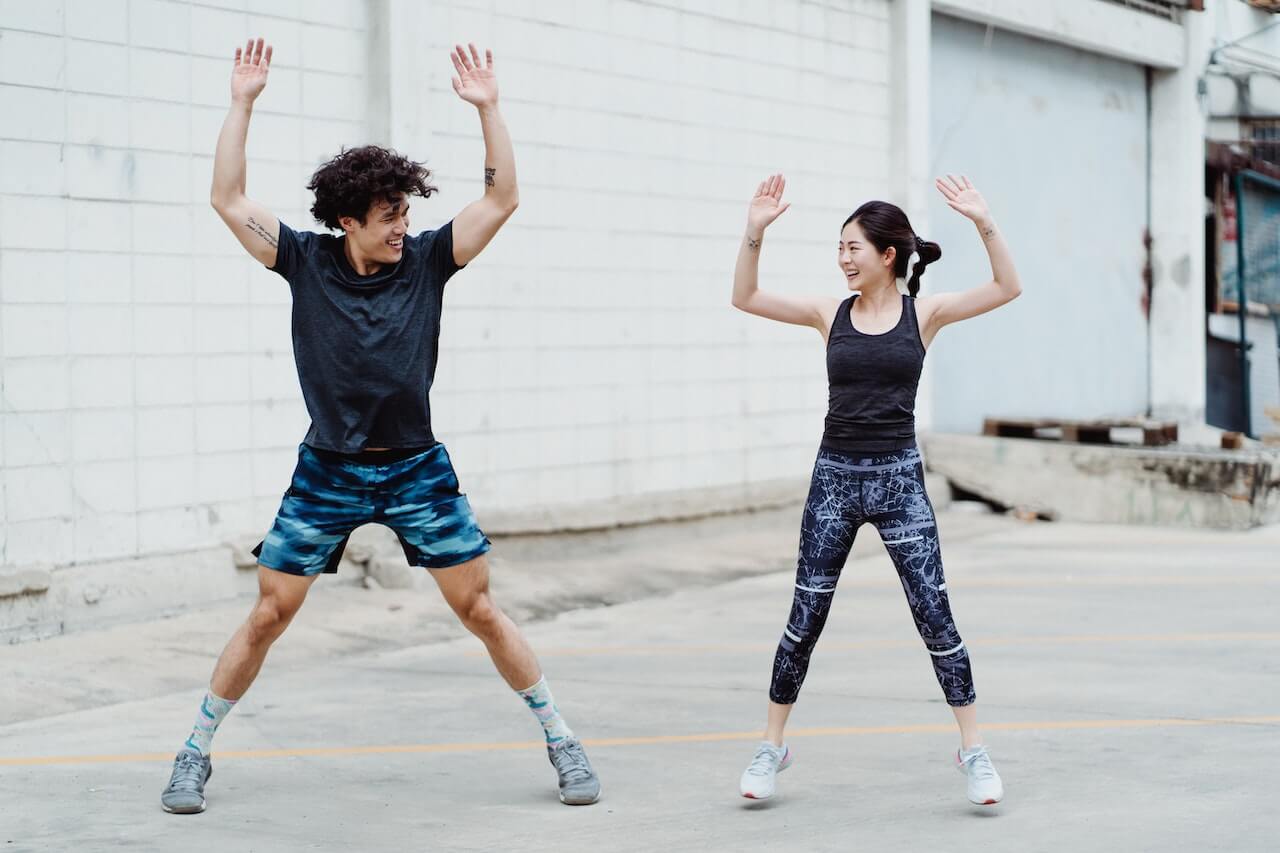 two-people-doing-jumping-jacks-outdoors