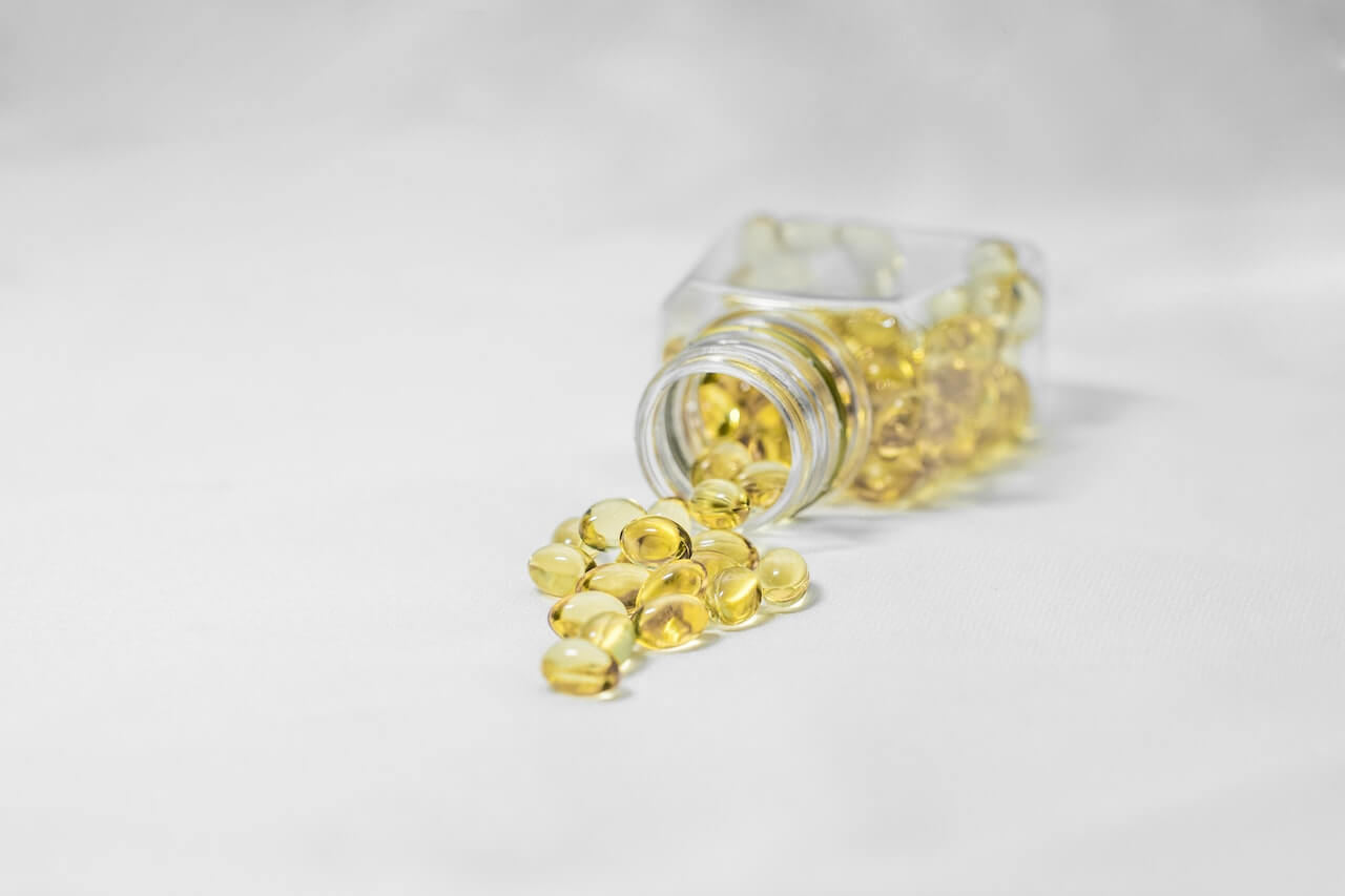 yellow-soft-gel-capsules-on-white-surface