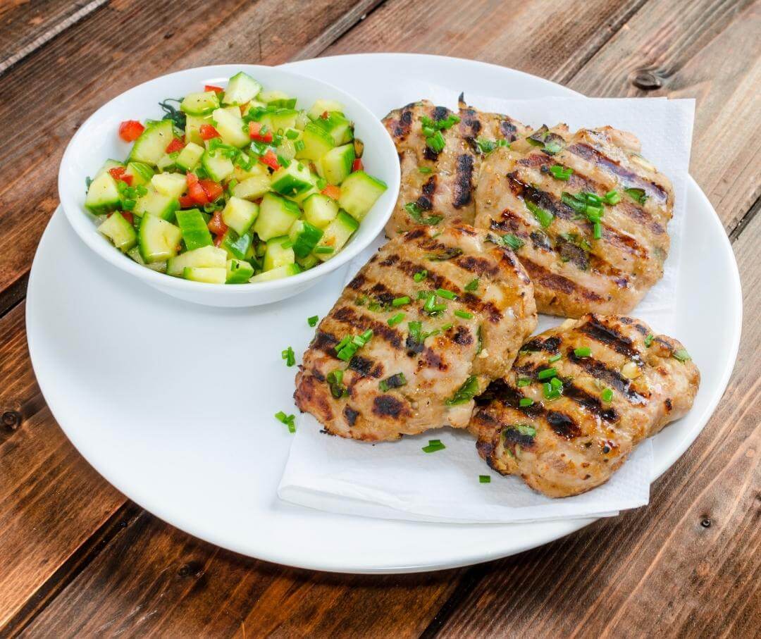 grilled turkey burgers with a side salad of cucumber and red pepper