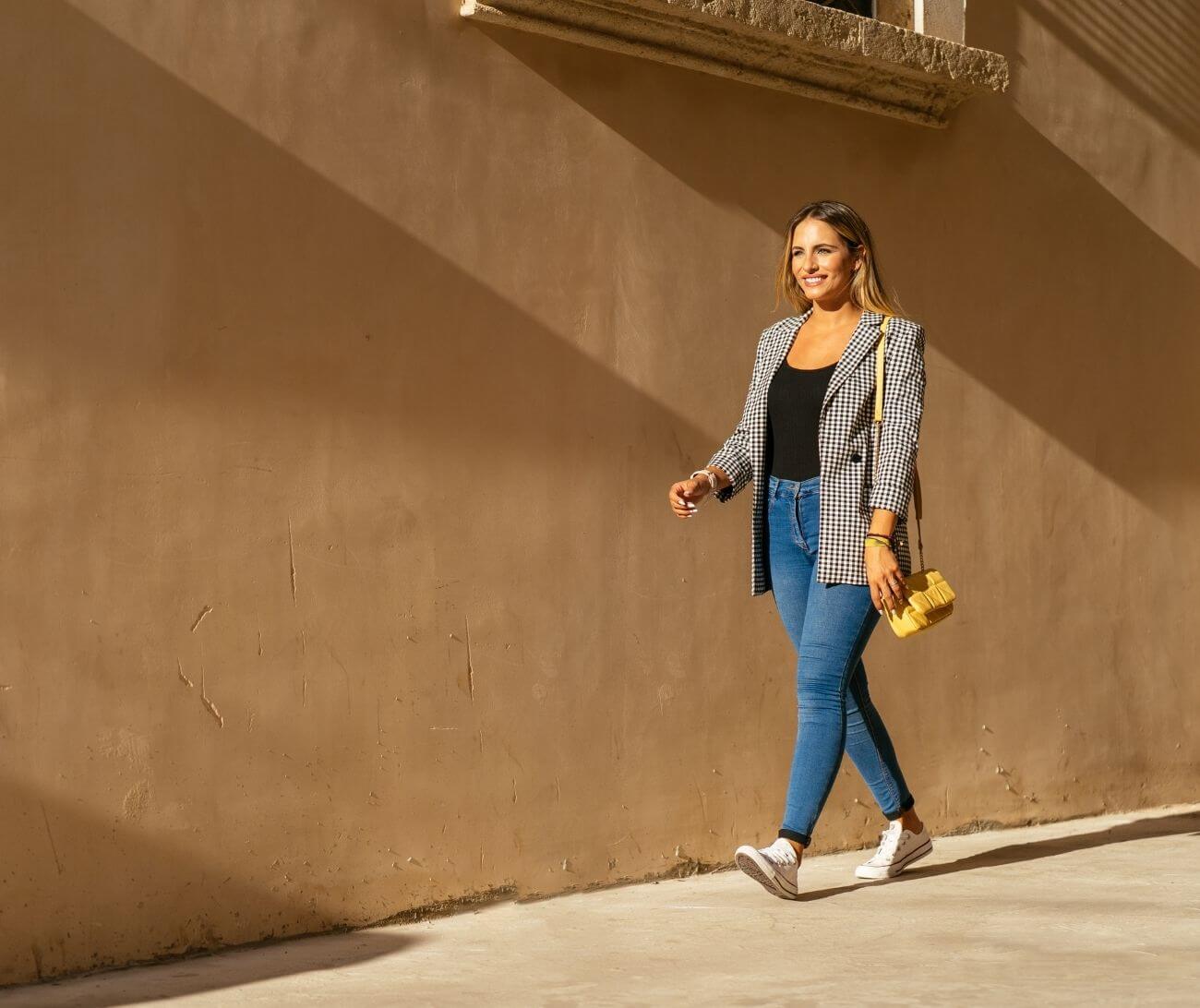 woman walking down an urban sidewalk during the day