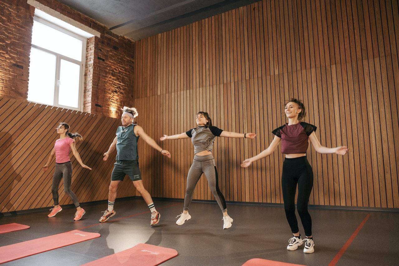 four-people-at-workout-class-doing-jumping-jacks