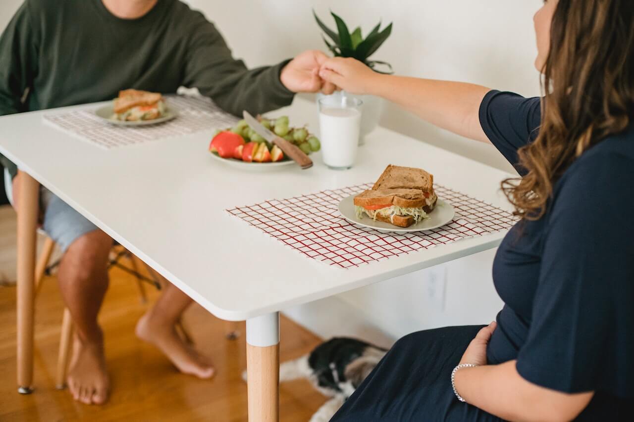 couple-eating-sandwich-and-fruit-for-dinner