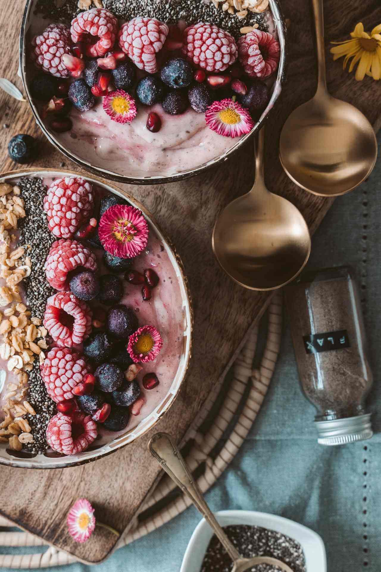 two-acai-bowls-with-mixed-berries-and-flax-seeds-on-wooden-table