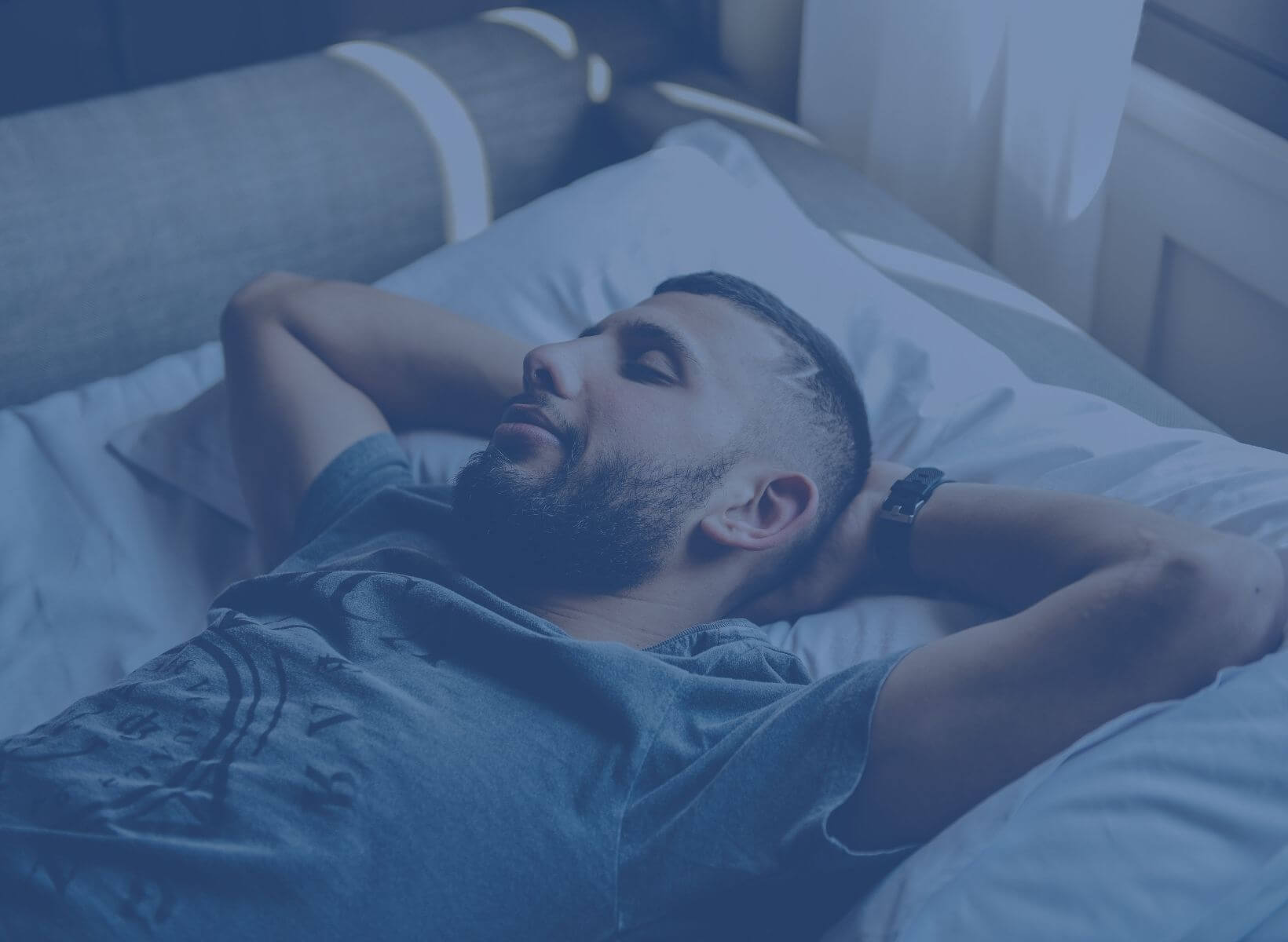 man sleeping with his arms resting behind his head