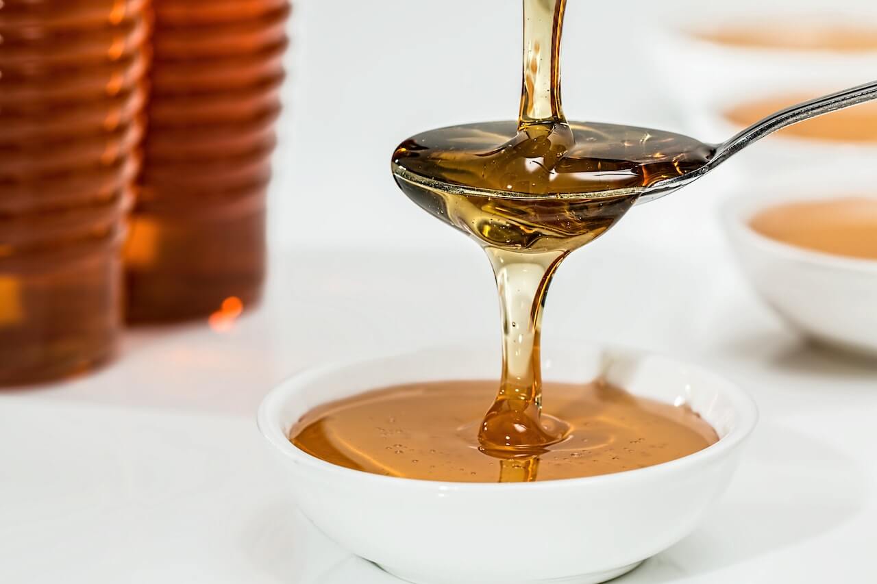 Honey-dripping-from-spoon-to-little-bowl