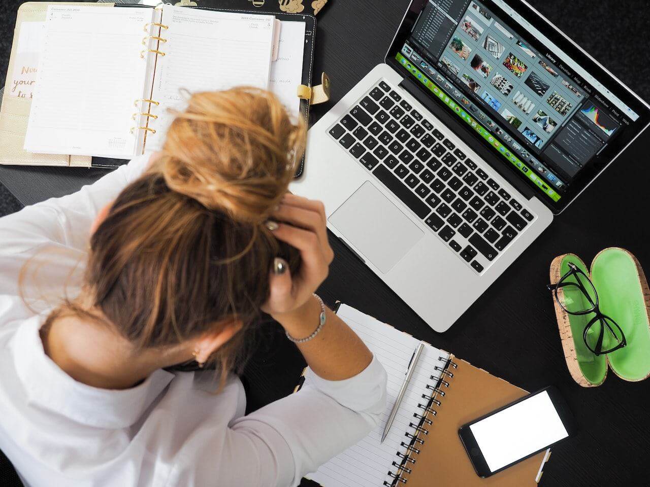 woman-stressed-with-her-work-in-front-of-her