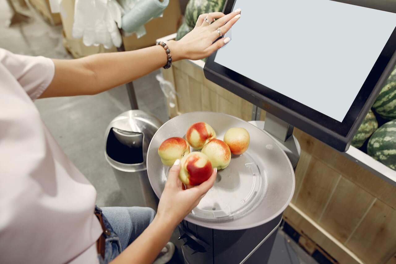 woman-with-apples-on-weight-scale-at-supermarket