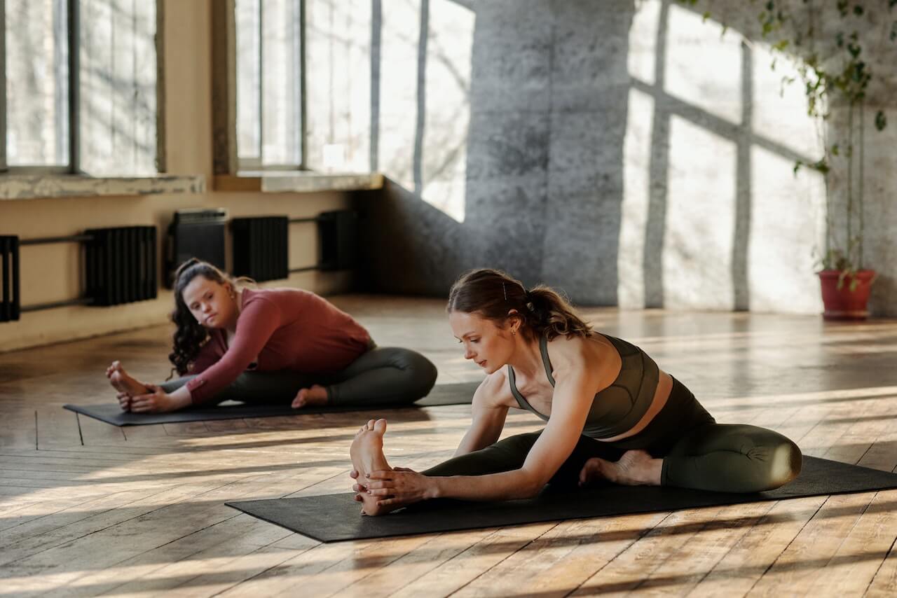 Yoga-teacher-giving-class-to-woman-with-disabilities-at-studio