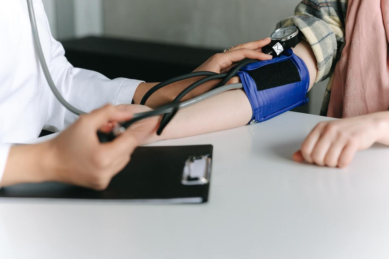 doctor-taking-someones-blood-pressure-with-machine