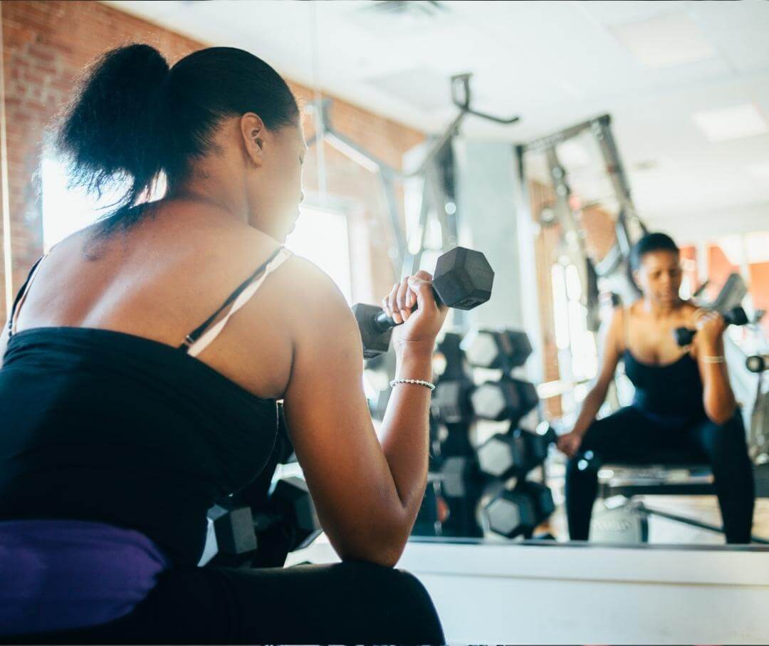 woman doing bicep curls in a gym