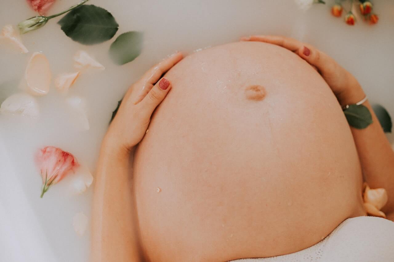 pregnant-woman-touching-her-belly-in-bath