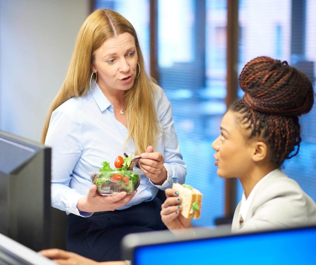 two women eating lunch in an office