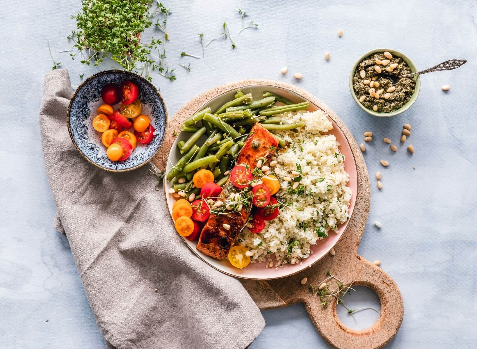 Overhead show of a low-glycemic diet plan meal of salmon, green beans, tomatoes, and cous cous