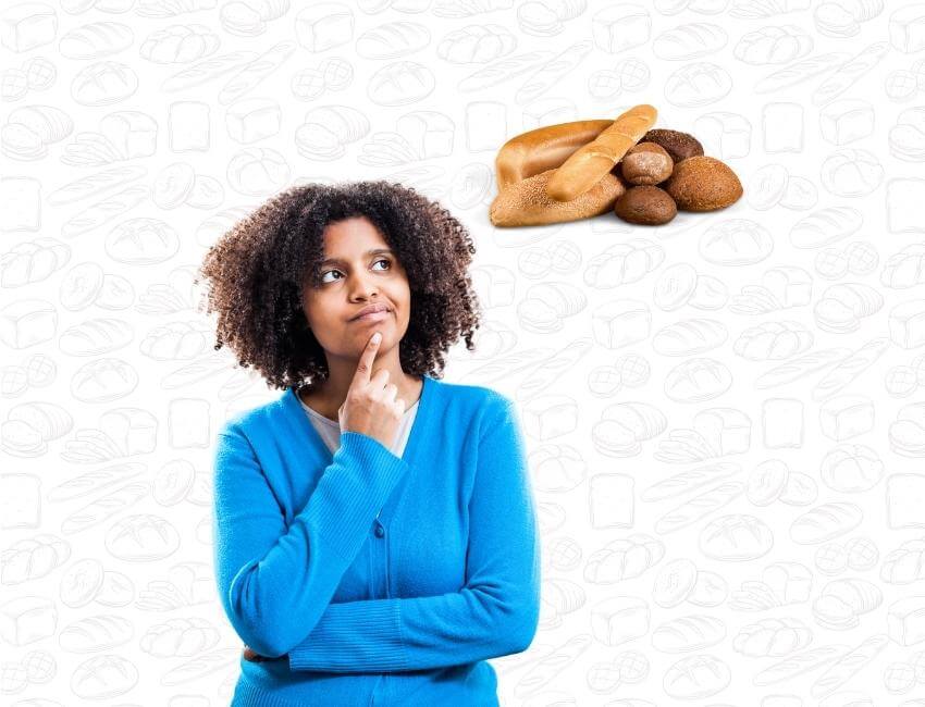 A woman inquisitively looking at a stack of bread loaves