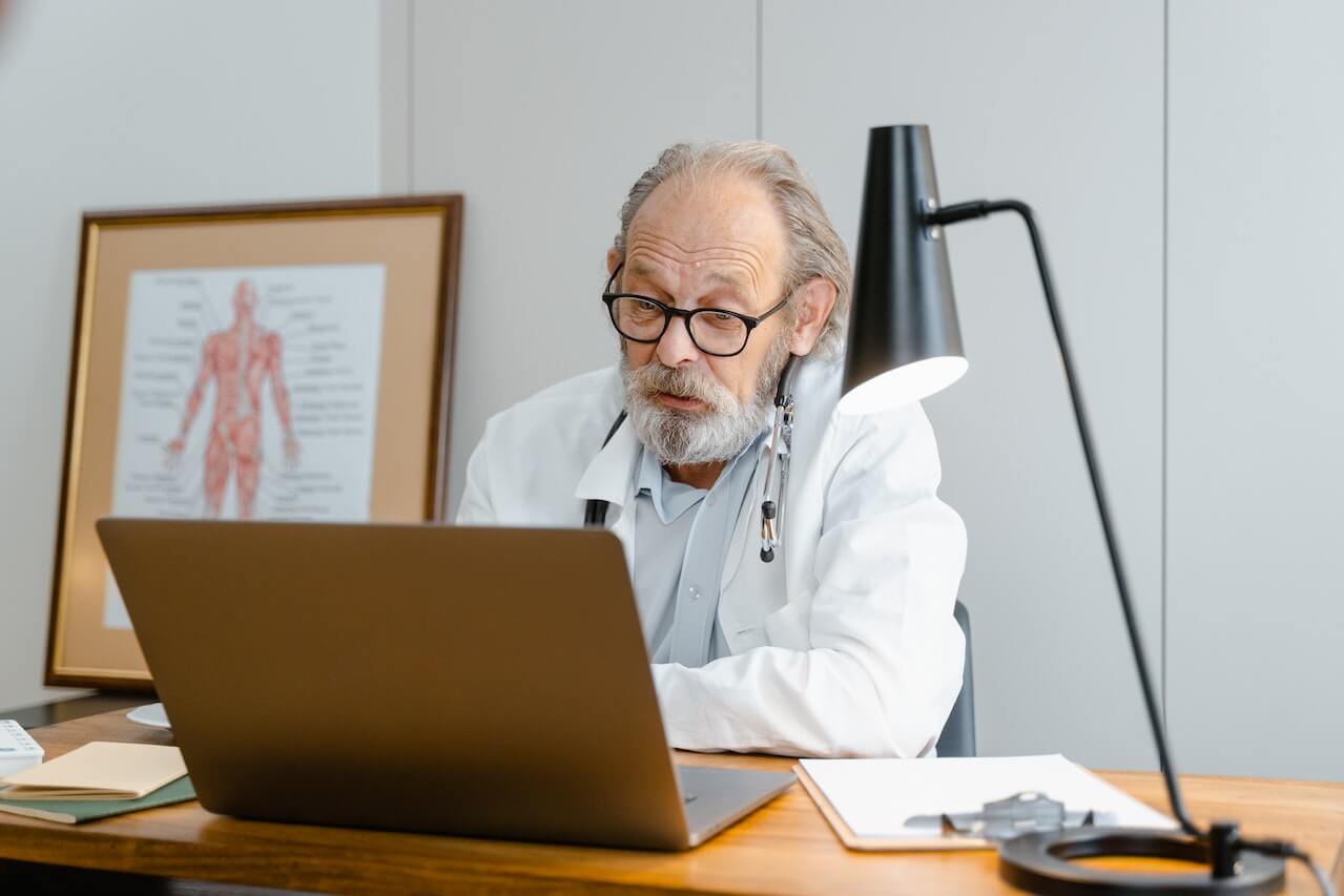 doctor-in-white-lab-coat-talking-while-facing-the-laptop